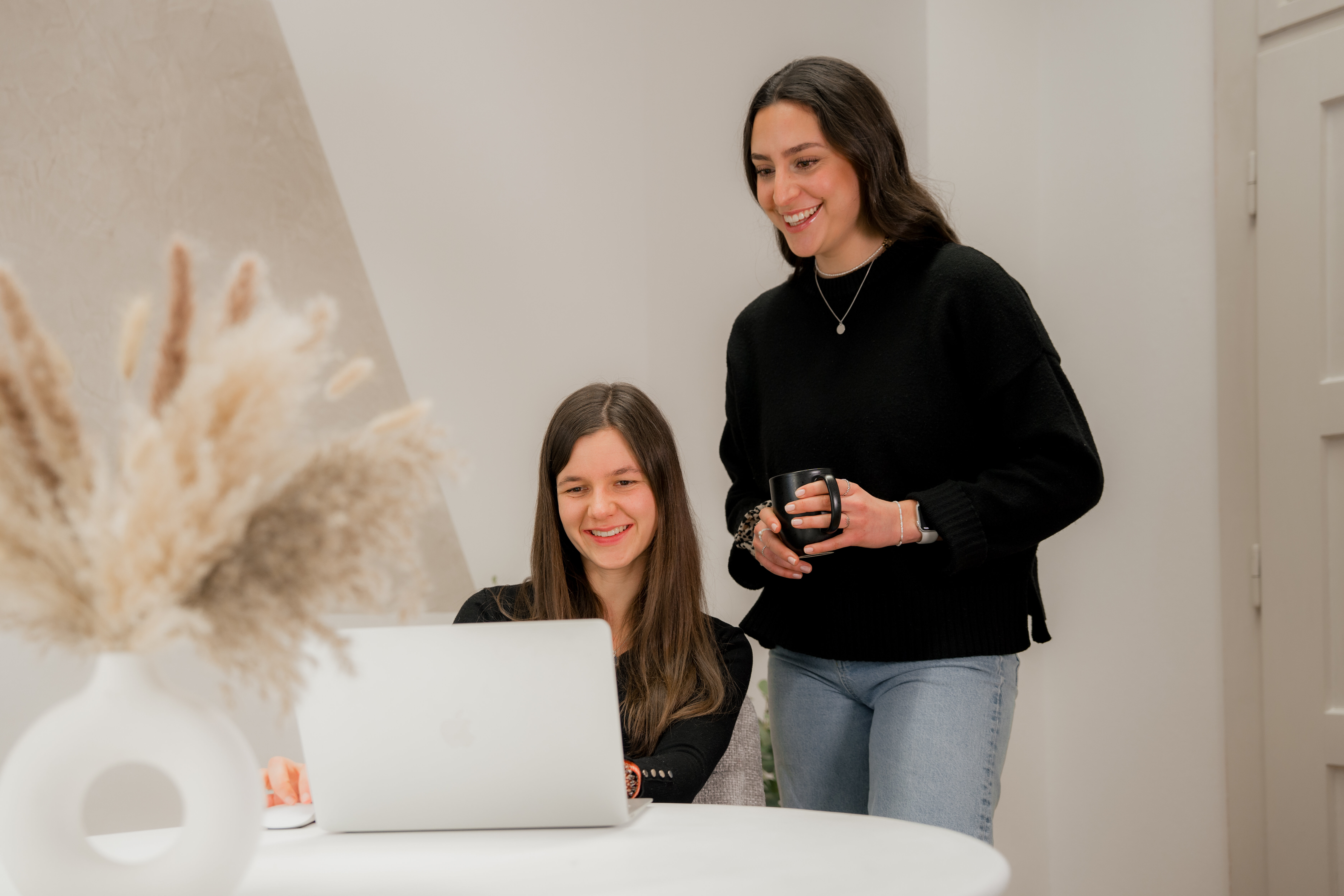 Lily und Annalena, SEO-Expertinnen bei LL-Marketing, schauen gemeinsam auf Bildschirm im Office von LL-Marketing | © bridgeagency Janine Brugger