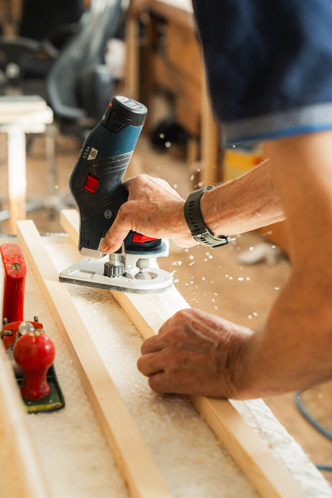 Eine Nahaufnahme wie ein Stück Holz mit einem Hobel bearbeitet wird