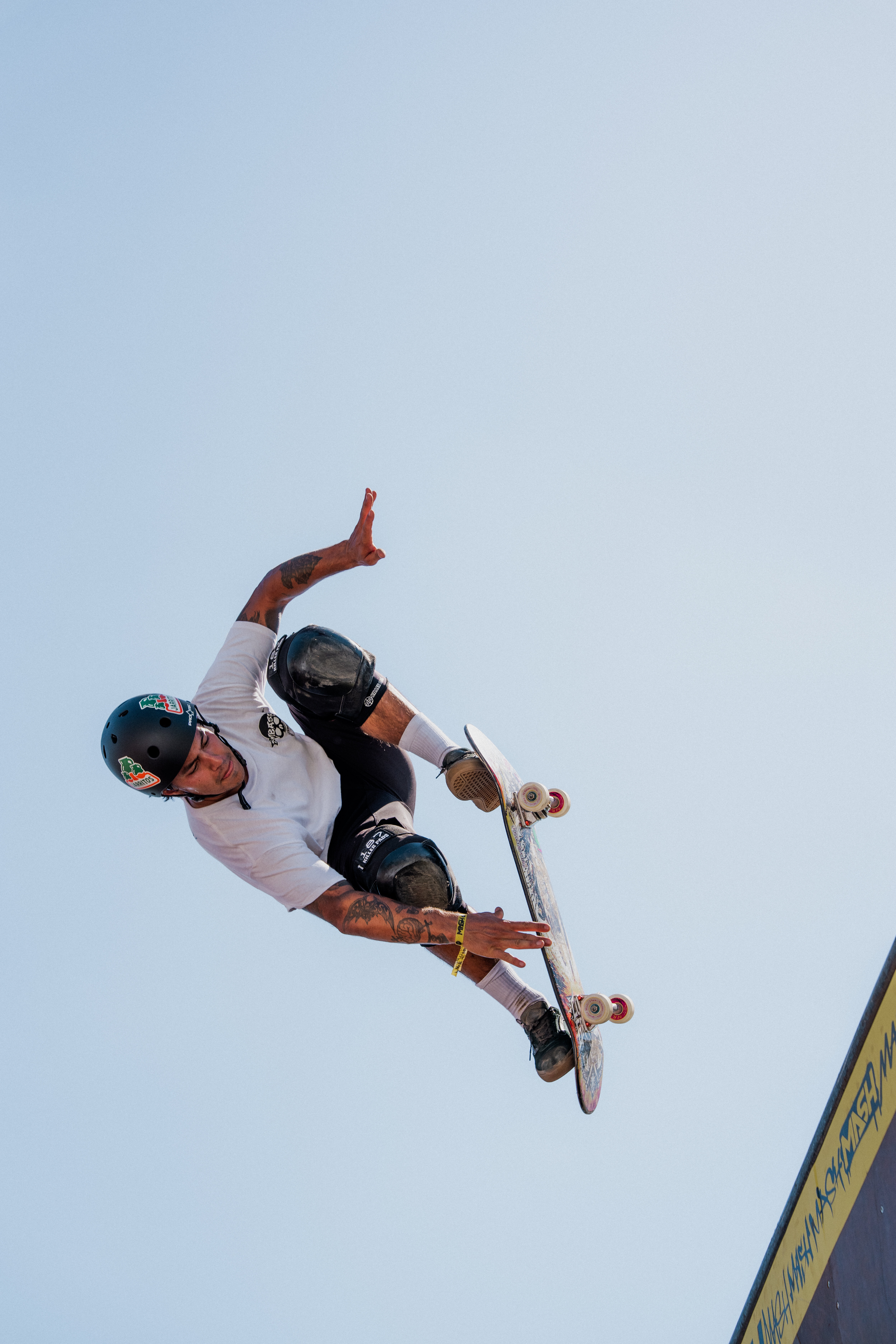 Ein Skateboard Fahrer wie er gerade in der Luft ist und an sein Skateboard greift