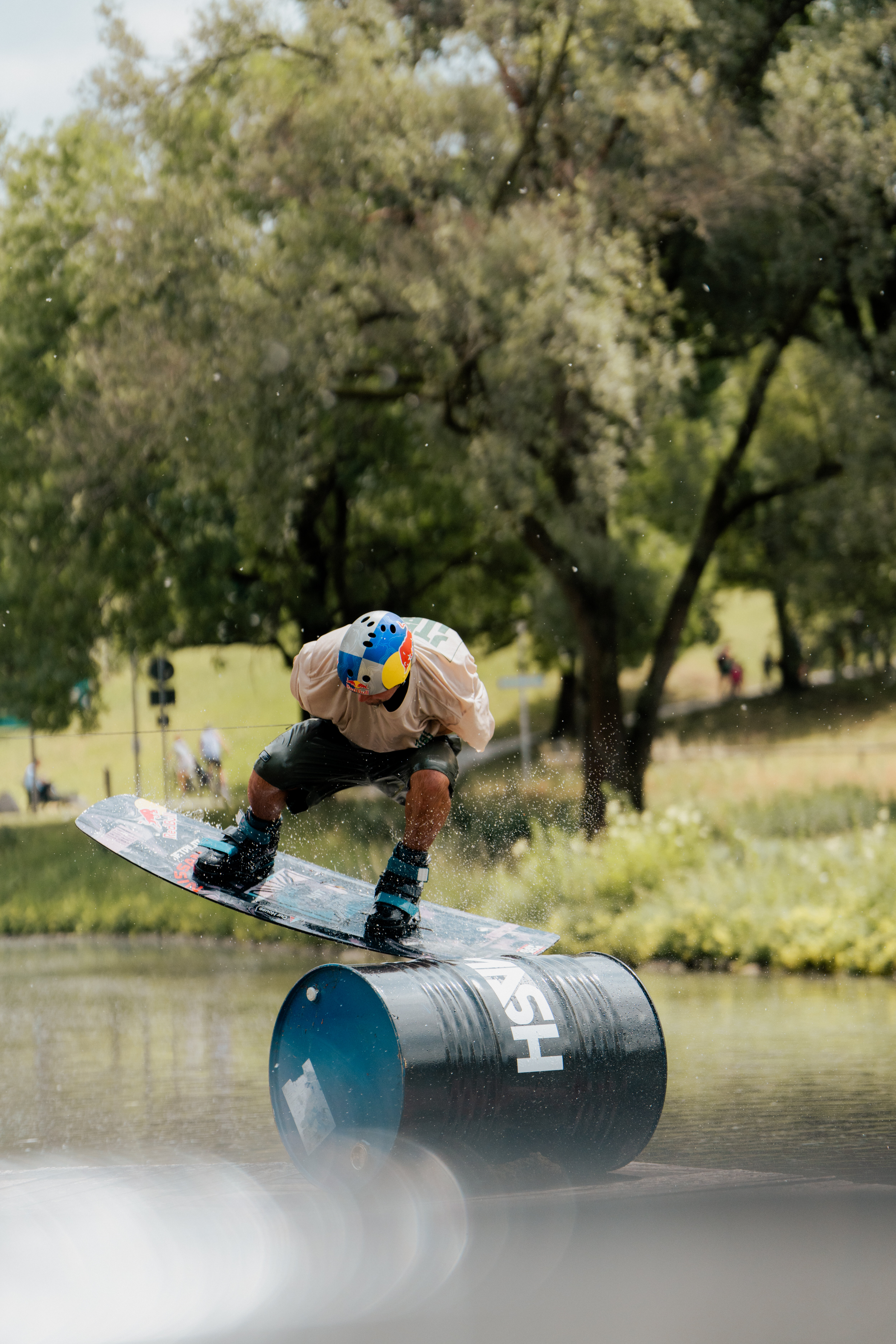 Ein Wakeboarder wie er gerade über eine Tonne springt