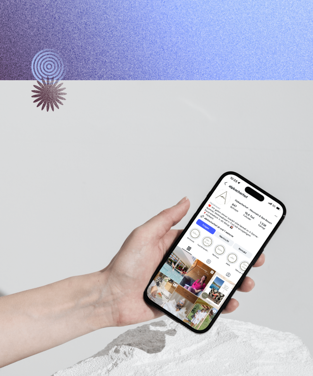 Eine Hand die ein Handy hält mit dem Instagramprofil des Alpbacherhofs